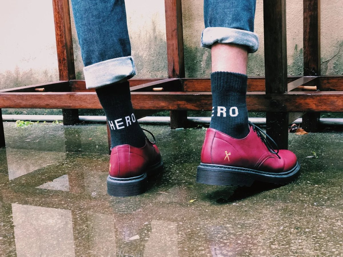 Par de sapatos King55 vermelhos com meia preta escrita HERO, em dia de chuva