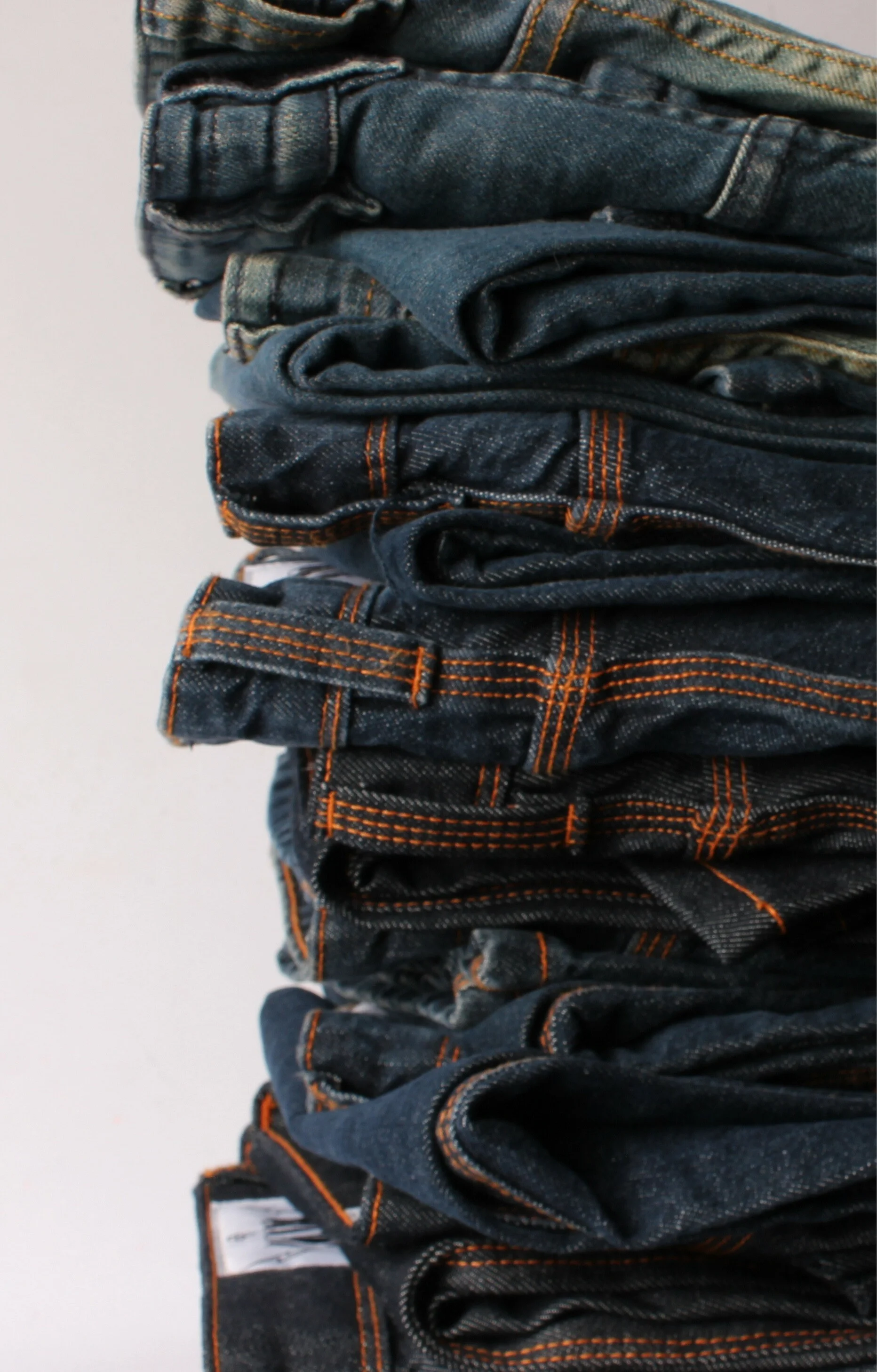 Pilha alta de calças jeans KING55 dobradas, recebidas pelo programa
